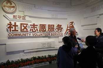 参会嘉宾在社区志愿服务展馆内接受采访